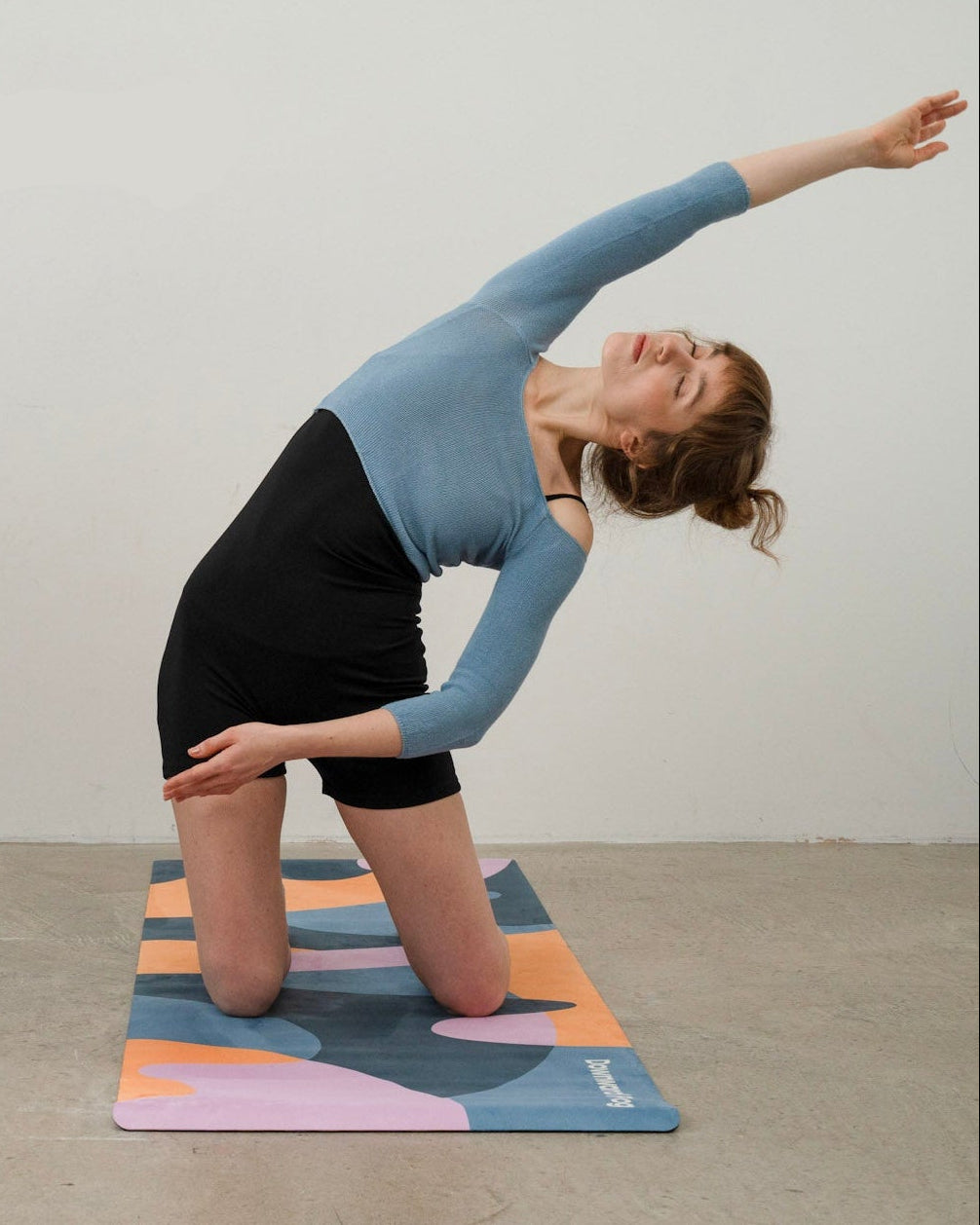 Women practicing yoga on colorful yoga mat in a studio setting.